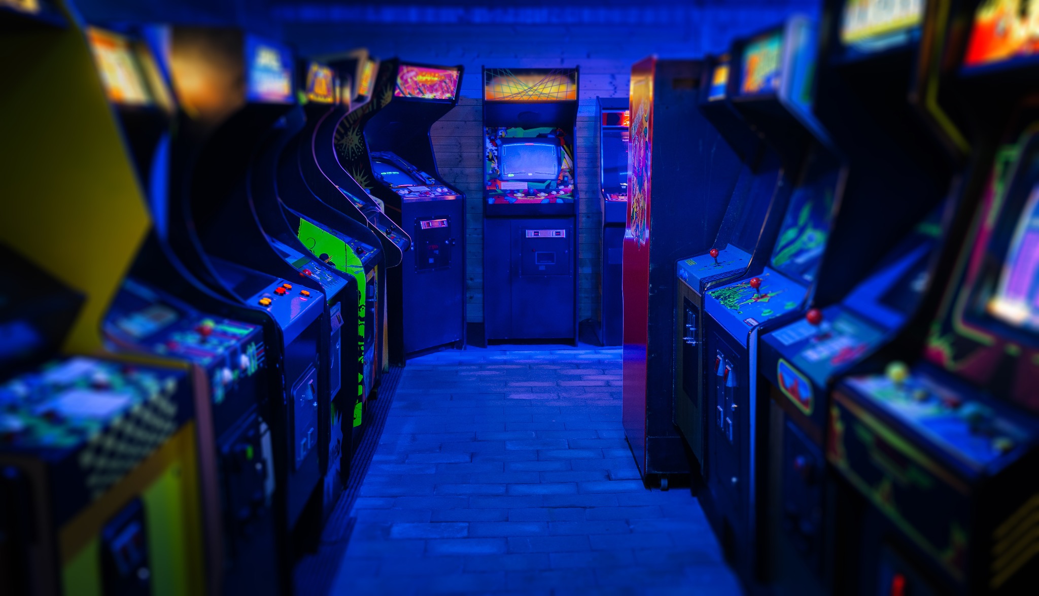 A row of arcade machines lit in blue